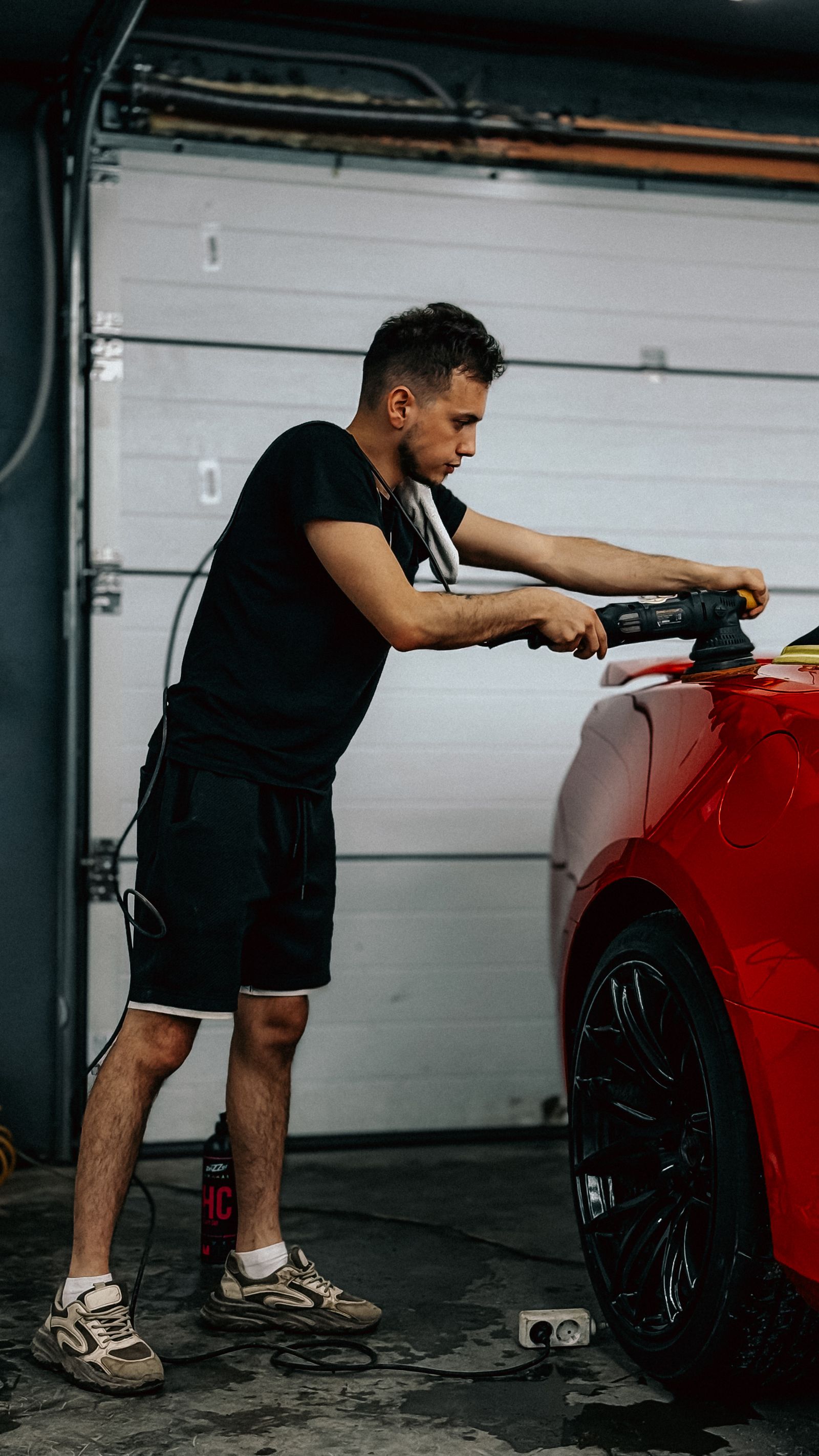 A technician carefully buffing and finishing a vehicle panel