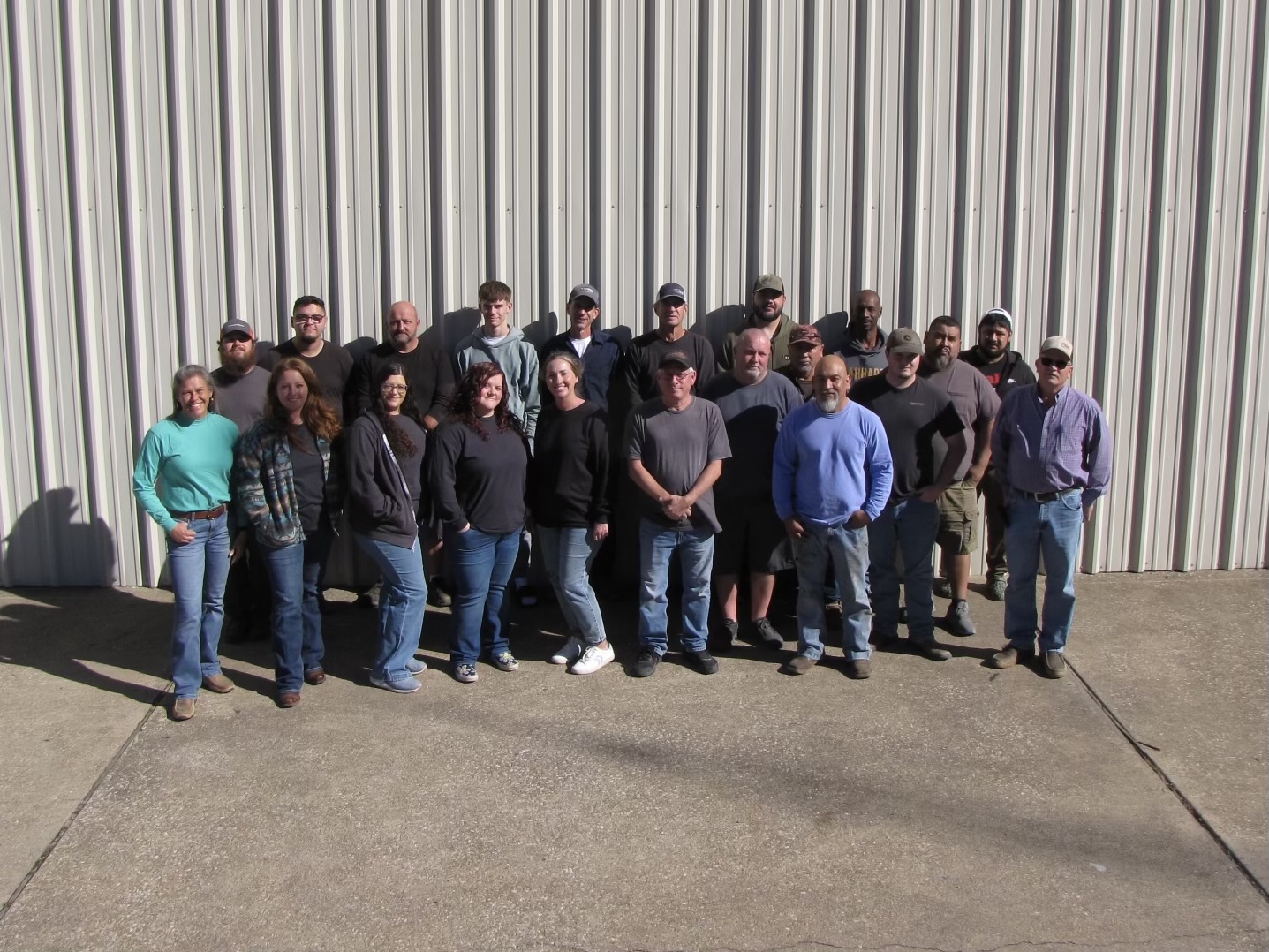 A group of auto repair technicians standing together in a shop